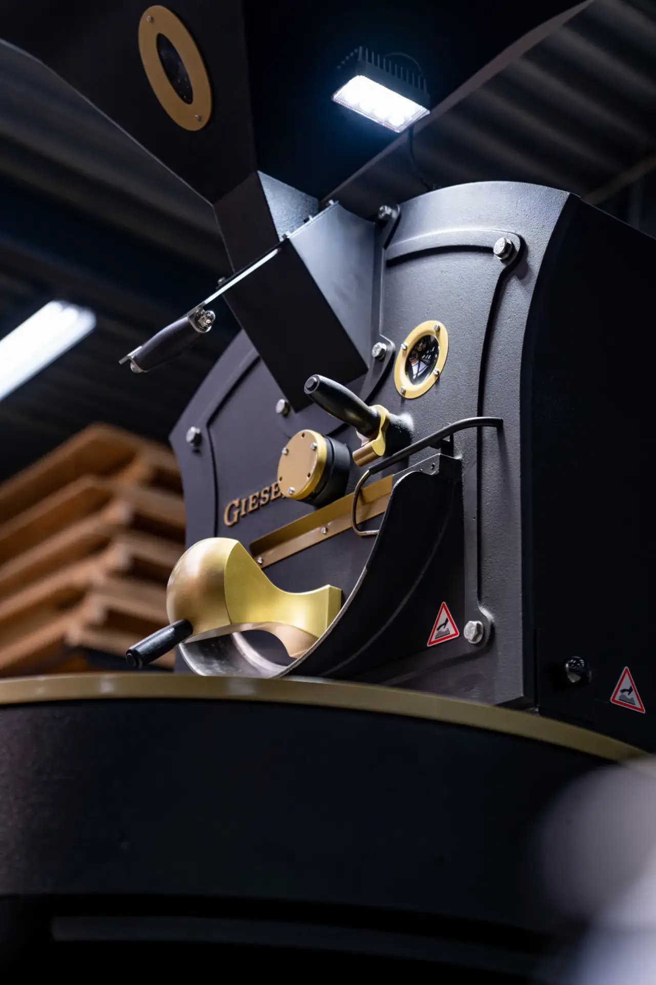 Close-up detail of a Giesen coffee roaster's drum door and brass fittings