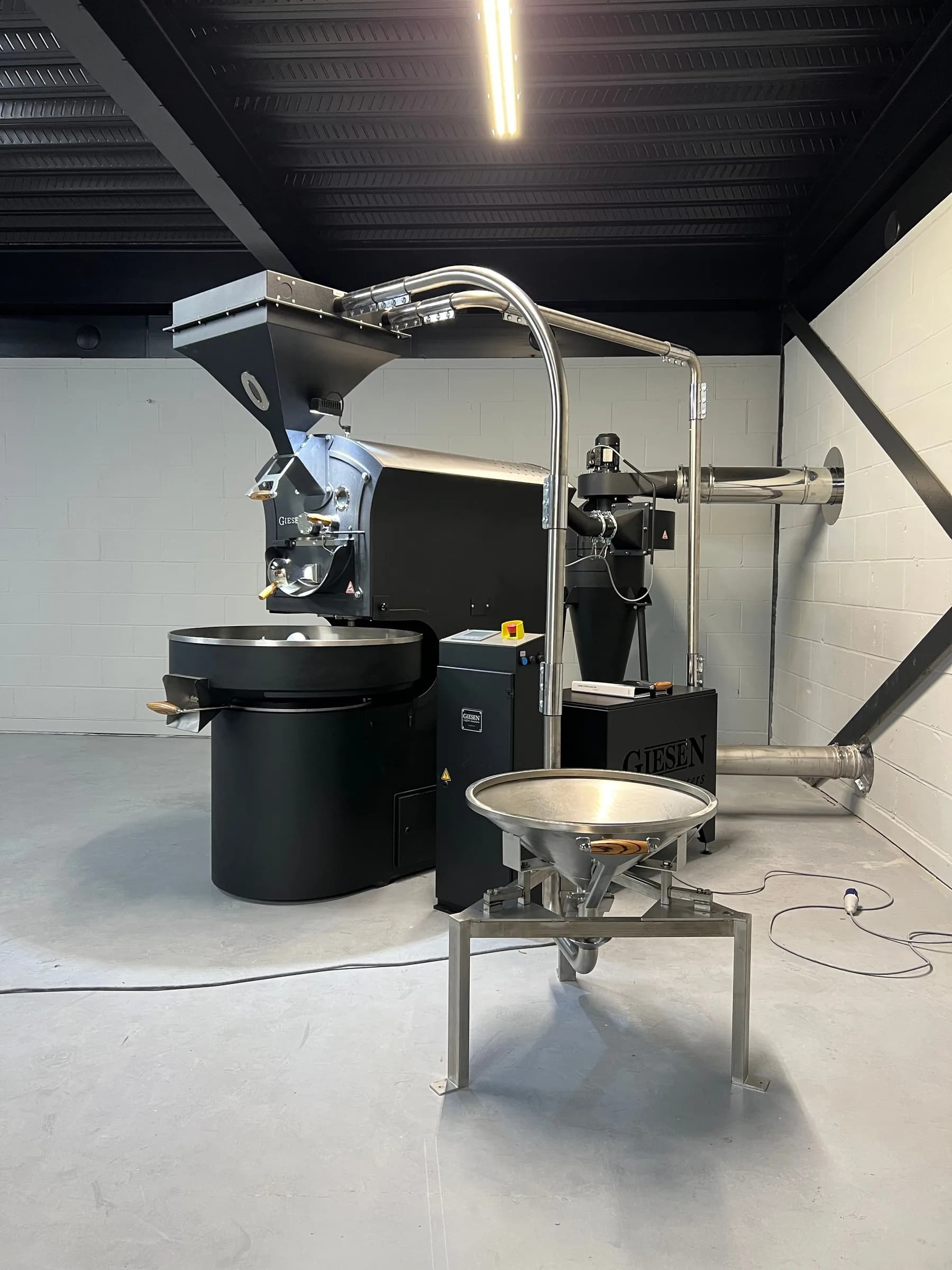 Rear of a Giesen roaster with ducting, a destoner and open floor for service access